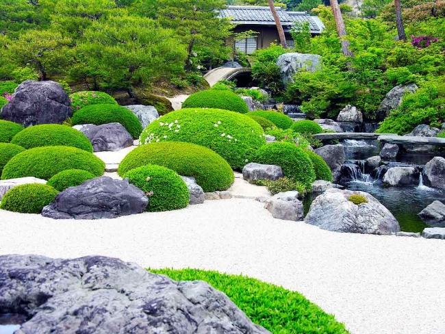 giardino giapponese cespugli forme svariate laghetto circondato pietre sentieri ghiaia