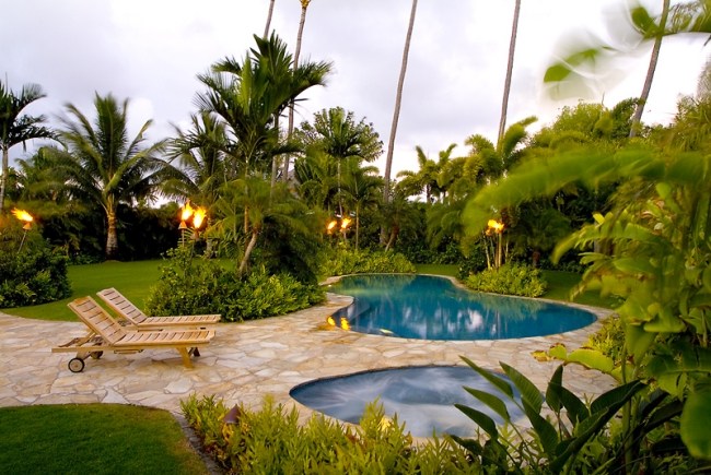 giardino tropicale circondato palme piscina lettini prendisole