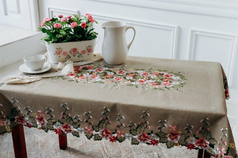 tavolo do legno rettangolare tovaglia grigia con motivi floreali vaso di fiori freschi