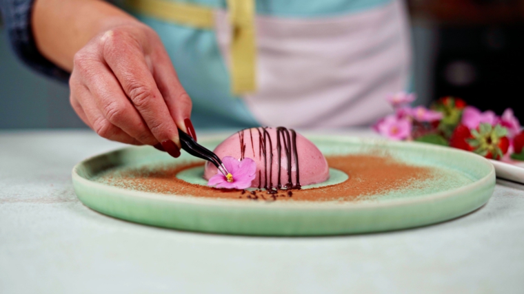 ricetta panna cotta ai lamponi decorazione con fiorellino piatto decorato con cacao in polvere