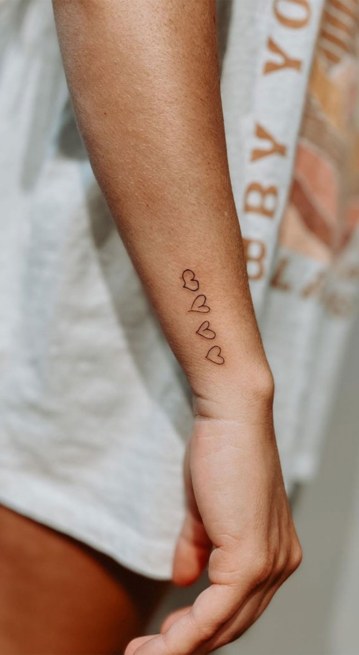 disegno tattoo cuori sull avambraccio di una ragazza