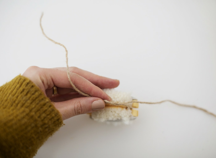 Addobbi natalizi fatti a mano, strumento per fare i pompon, filo di lana e spago