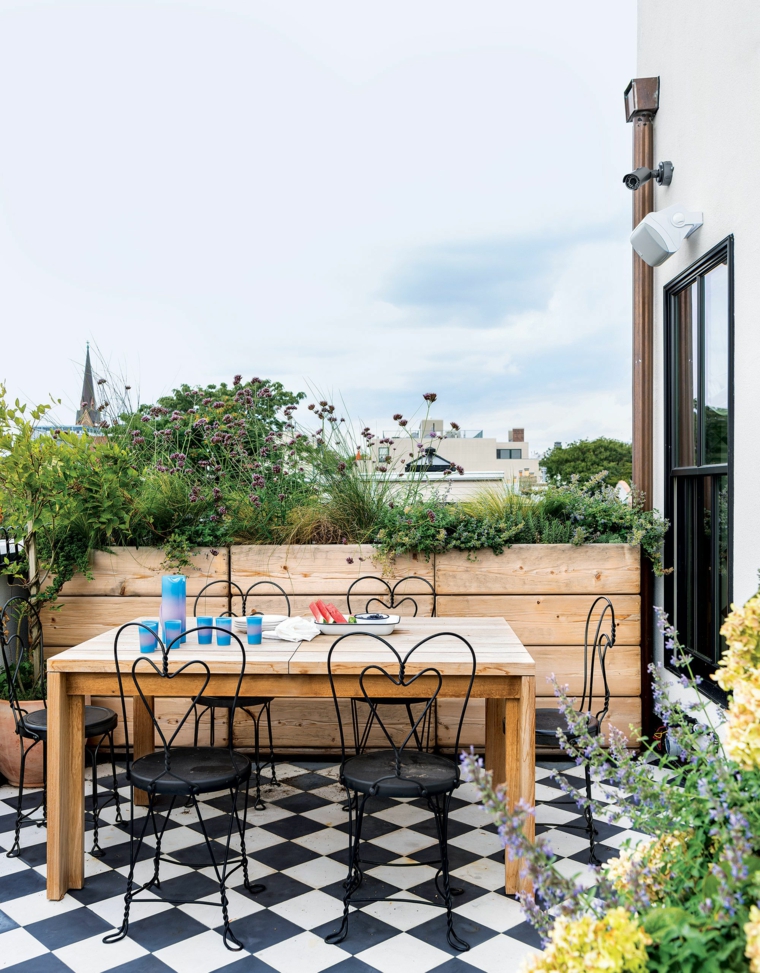 arredare terrazzo appartamento con tavolo di legno e sedie di metallo pavimento con piastrelle