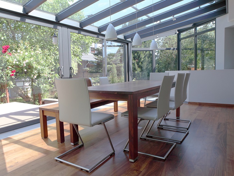 veranda arredata tavolo legno sedie bianche design moderno