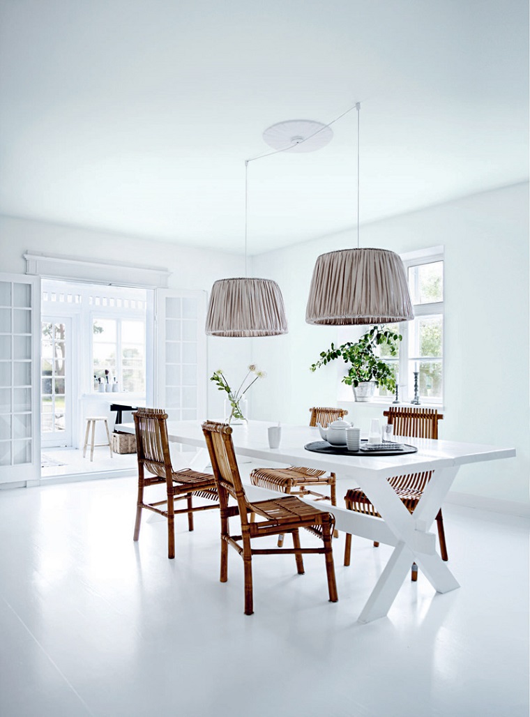 sala da pranzo arredata mobili bianchi sedie legno lampade