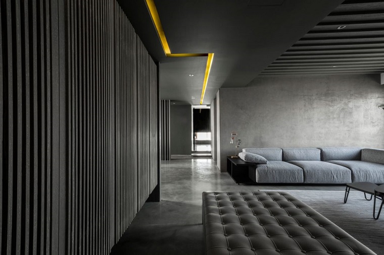 Soggiorno con pareti di colore grigio, divano in tessuto grigio, arredamento stile industriale