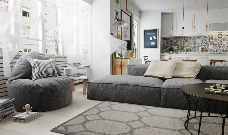 Soggiorno con divano di colore grigio, pouf poltrona, salotto con tappeto geometrico