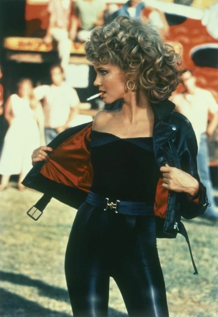 abbigliamento-anni-80-olivia-newton-john -greese-leggins-neri-giubbino-pelle-nera-cintura nera-sigaretta