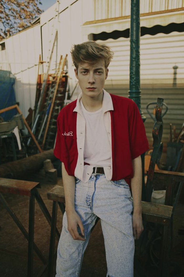 anni-80-look-giovane-ragazzo-jeans-giacca-rossa-camicia-bianca-capelli-biondi-ciuffo