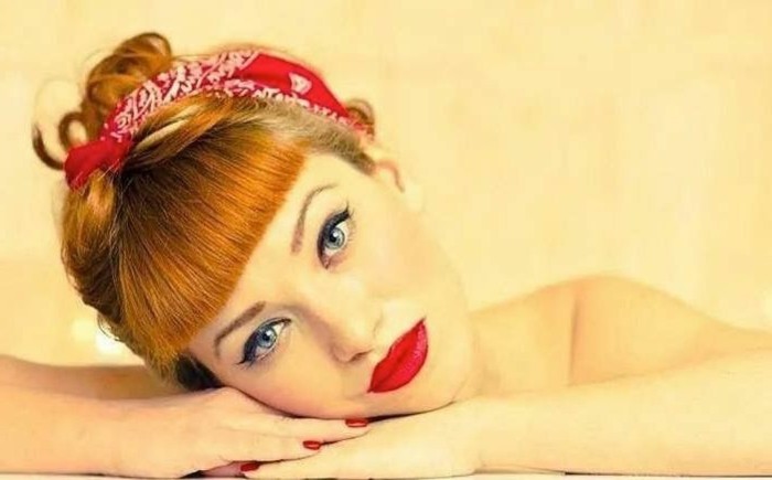 idea-acconciatura-donna-stile-anni-50-capelli-chiari-fascia-rossa-rossetto-lucido-testa-appoggiata