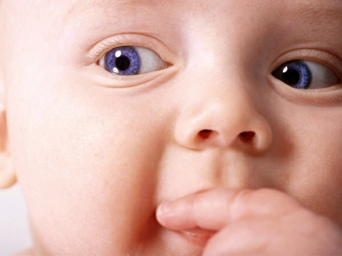significato-del-colore-degli-occhi-blu-piccolo-bambino-dito-in-bocca-bella-foto