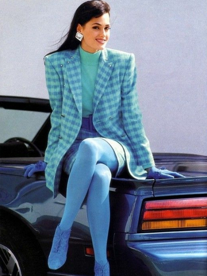 vestiti-anni-80-donne-giacca-scacchi-blu-azzurro-molto-ampia-spalline-maglione-collo-alto-gonna-collant-guanti-blu-grandi-orecchini
