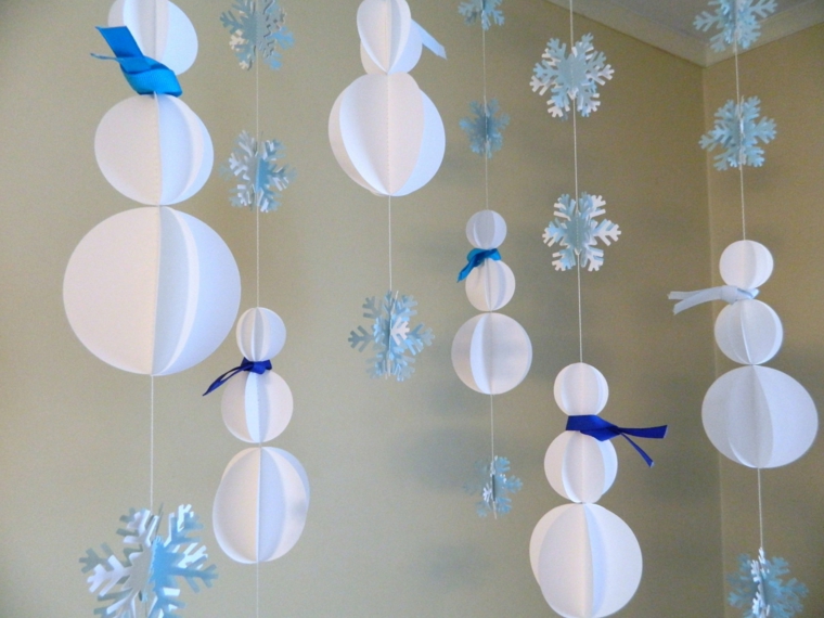 decorazioni natalizie, delle ghirlande con dei fiocchi e dei pupazzi di neve bianchi e blu da appendere