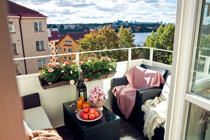 arredo-terrazzo-piccolo-set-mobili-da-esterno-vimini-colore-nero-tavolino-decorazioni-piante-ringhiera-cuscineria-coperte