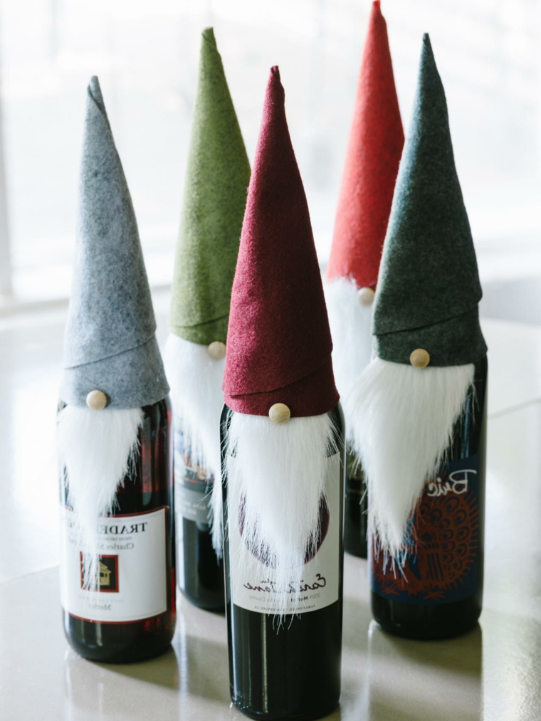 regali fatti in casa: delle bottiglie di vino trasformate in babbi natale con cappello e barba