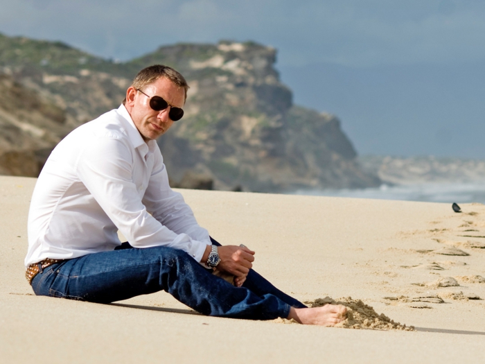 outfit-uomo-elegante-casual-camicia-colore-bianco-jeans-scuri-occhiali-da-sole-spiaggia-sabbia