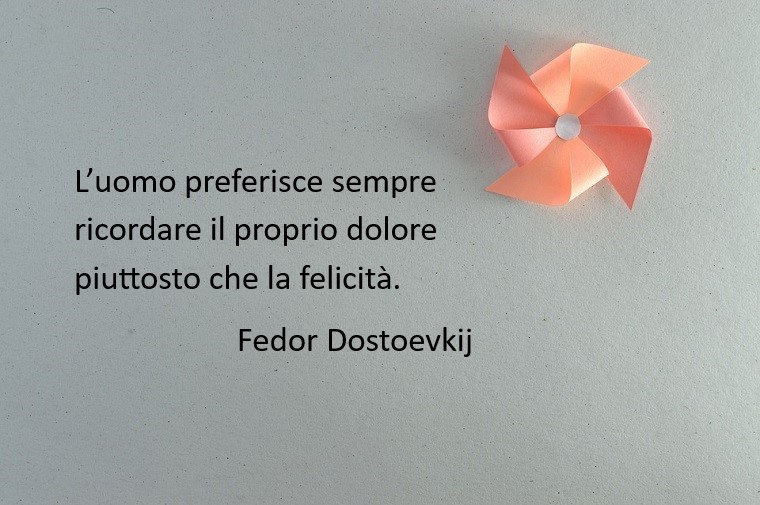 Immagine con sfondo grigio e una girandola colore rosa, citazione famosa di Fedor Dostoevskij