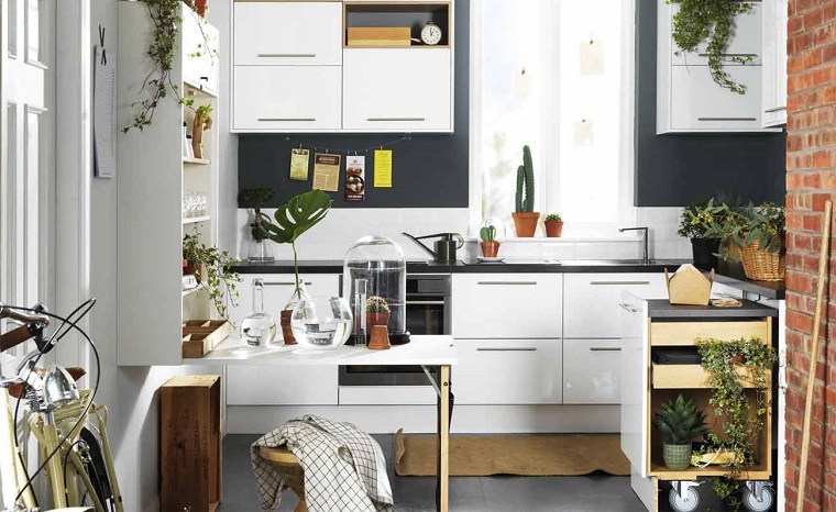 Come arredare la cucina con mobili di design con ante bianche e lucide, top di colore nero 