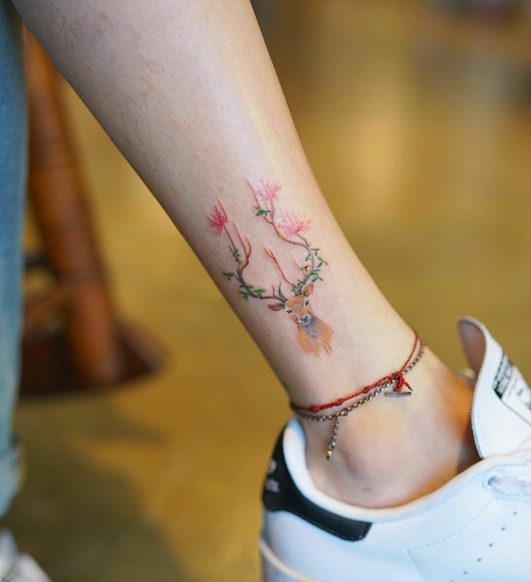 Tatuaggi femminili, tattoo disegno renna colorata, tatuaggio donna sulla caviglia, scarpe da ginnastica bianche