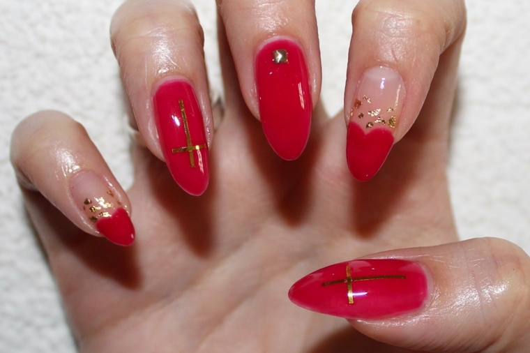 nail art rosso, una manicure con decorazioni oro e glitter su unghie a stiletto