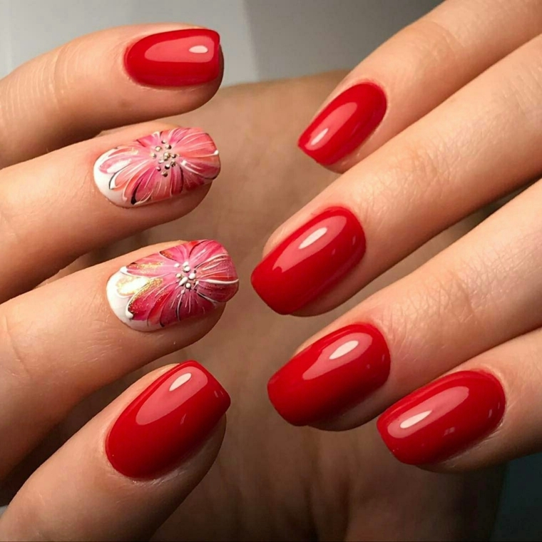 unghie in gel rosse, una manicure perfetta e brillante con anulare e medio finemente decorati