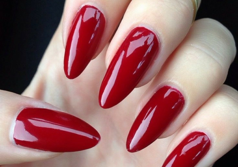 unghie rosse gel, forma a stiletto e finitura extra lucida per un risultato chic