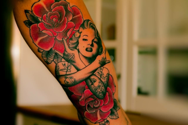 tatuaggio in stile tradizionale raffigurante due rose rosse con al centro marilyn