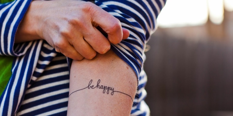 Tatuaggi piccoli, scritta Be Happy sul braccio di una donna, idea carina con significato 
