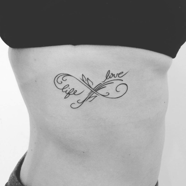 Tatuaggio infinito, idea con decorazione scritta Love e Life sulla pancia di una ragazza 