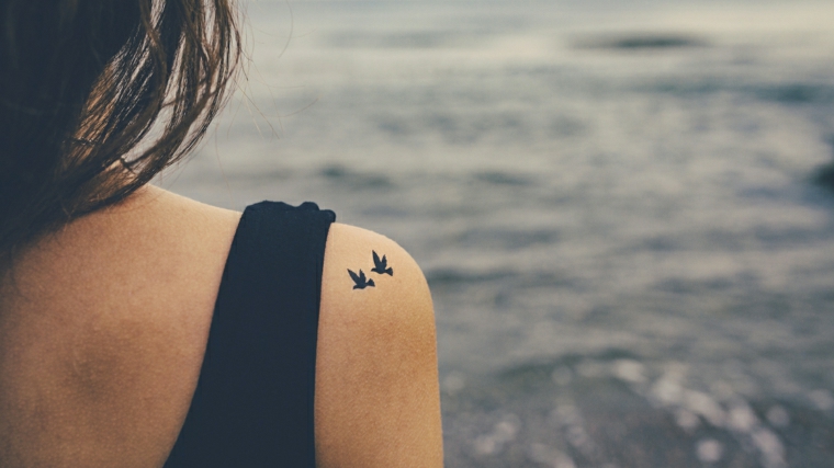 Tatuaggio uccelli sulla spalla di una ragazza, simbolo di libertà 