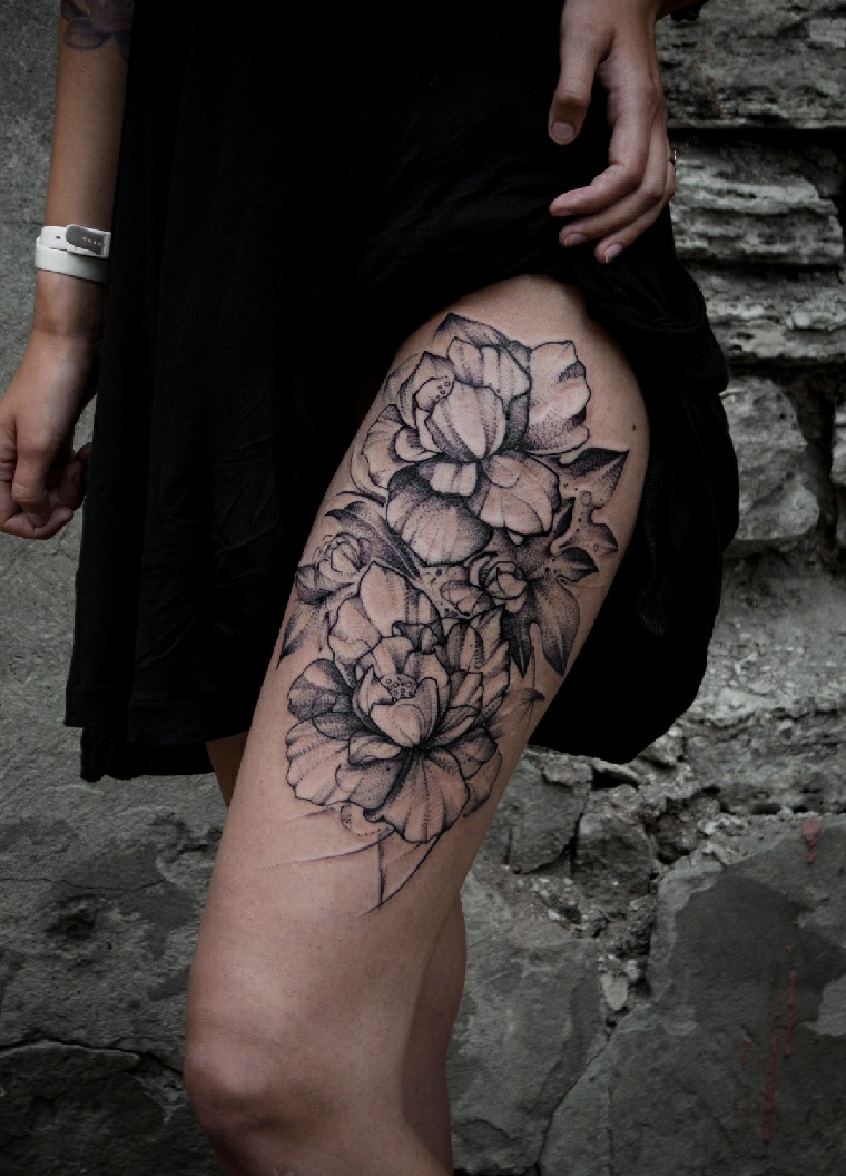 Disegno grande di un tatuaggio femminile sulla coscia di una ragazza, fiori e una rosa grandissima 
