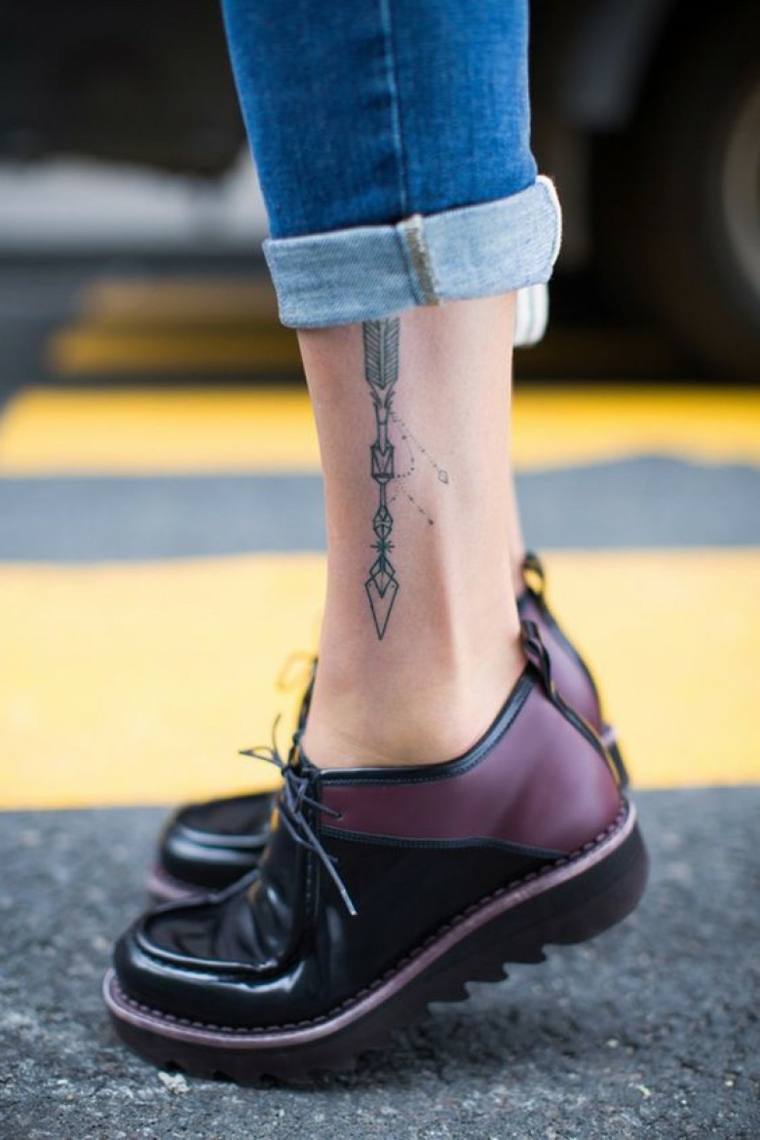 Tatuaggi femminili, tattoo disegno freccia con motivi geometrici, donna con jeans