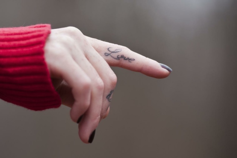 Tattoo particolari piccolo per donna, idea carina con la scritta Love sul pollice della mano 