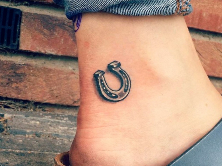 tatuaggio alla caviglia, un ferro di cavallo di piccole dimensioni all'insù