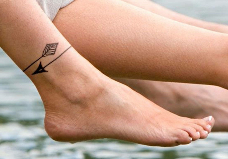 tatuaggi alla caviglia, idea con un disegno circolare raffigurante una freccia in bianco e nero