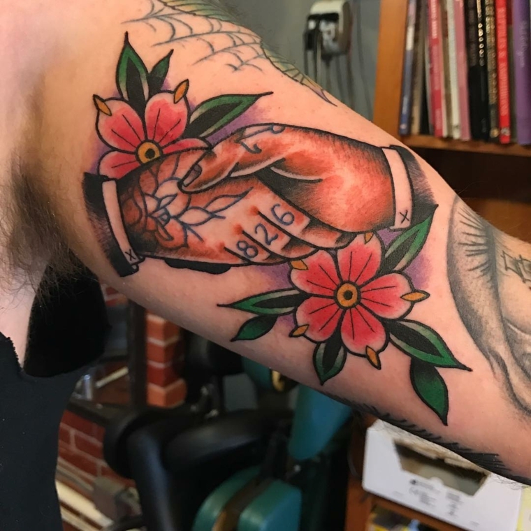 tattoo old school, due mani che si stringono con numeri e disegni e dei grandi fiori