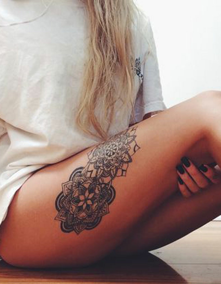 Mandala tattoo sulla coscia di una ragazza, disegno molto grande con sfumature e linee spesse 