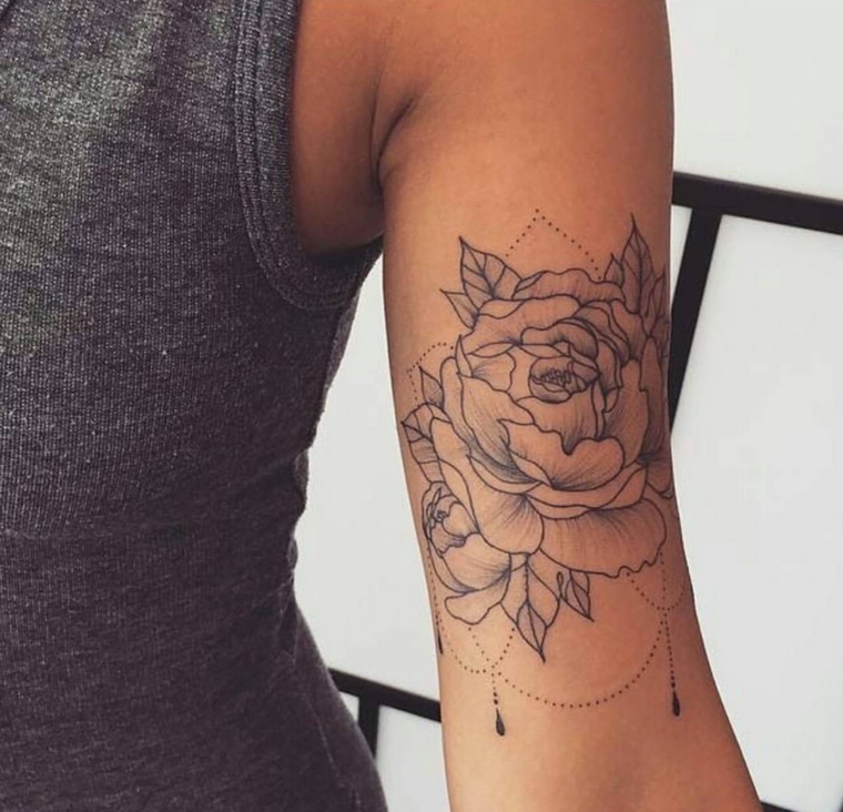 Tatuaggi donna, idea per un tattoo femminile sul braccio con una rosa e petali di colore nero 