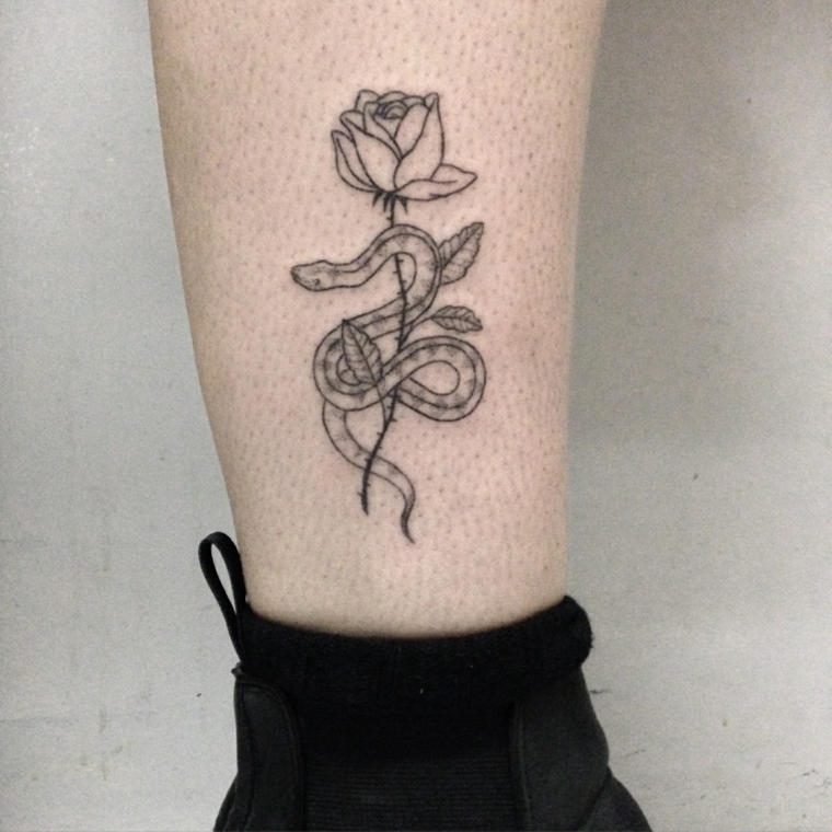 tatuaggio caviglia, una rosa in bianco e nera sul cui gambo si arrotola un serpente