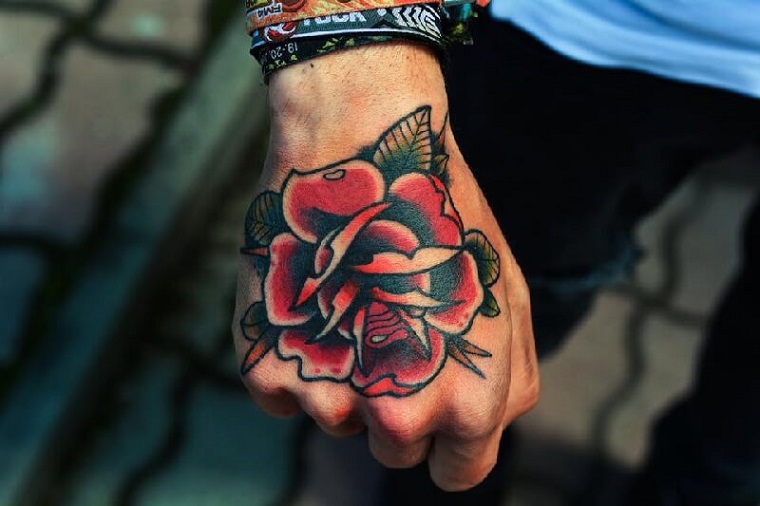 tatuaggio new school rosa tattoo sulla mano di un uomo colorato disegno rosa