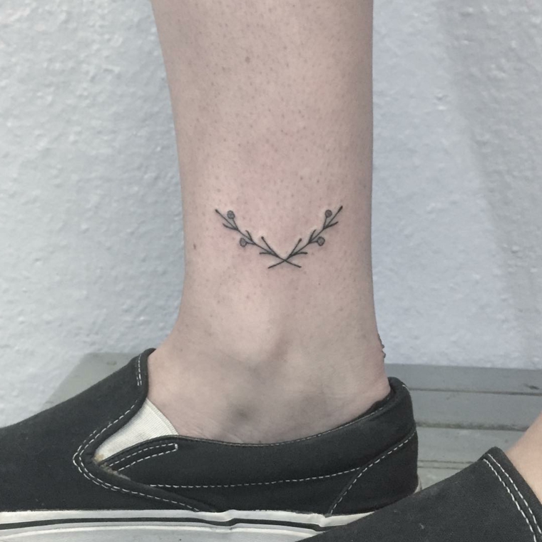 tattoo di dimensioni ridotte effettuato proprio sopra la caviglia raffigurante due ramoscelli