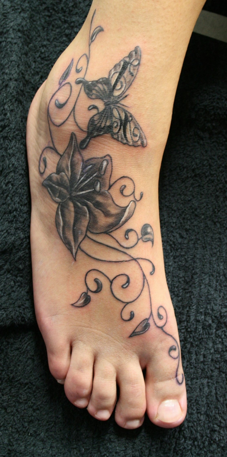tatuaggio alla caviglia, proposta per una donna con fiori e farfalle in bianco e nero