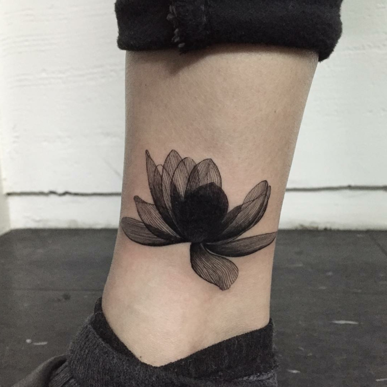 tatuaggi sulla caviglia, un fiore di loto particolare con dei petali neri aperti