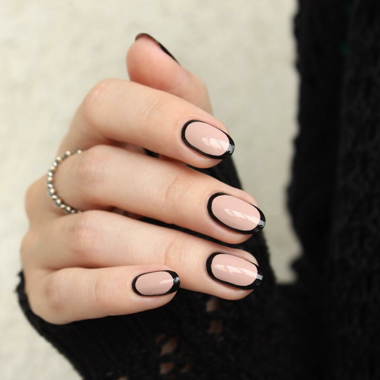 Come fare le unghie a mandorla, smalto color pelle con bordo nero, accessori donna in argento e un anello sul dito medio 