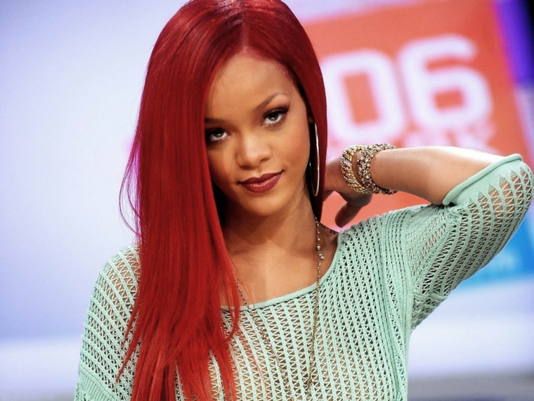 Tinta capelli di colore rosso per Rihanna, taglio lungo e liscio con leggera scalatura sulle lunghezze 