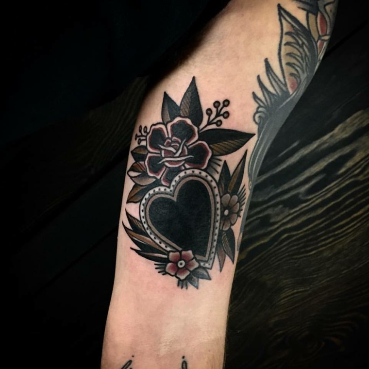 proposta di tatuaggio cuore di ampie dimensioni con l'interno nero e alcuni fiori intorno