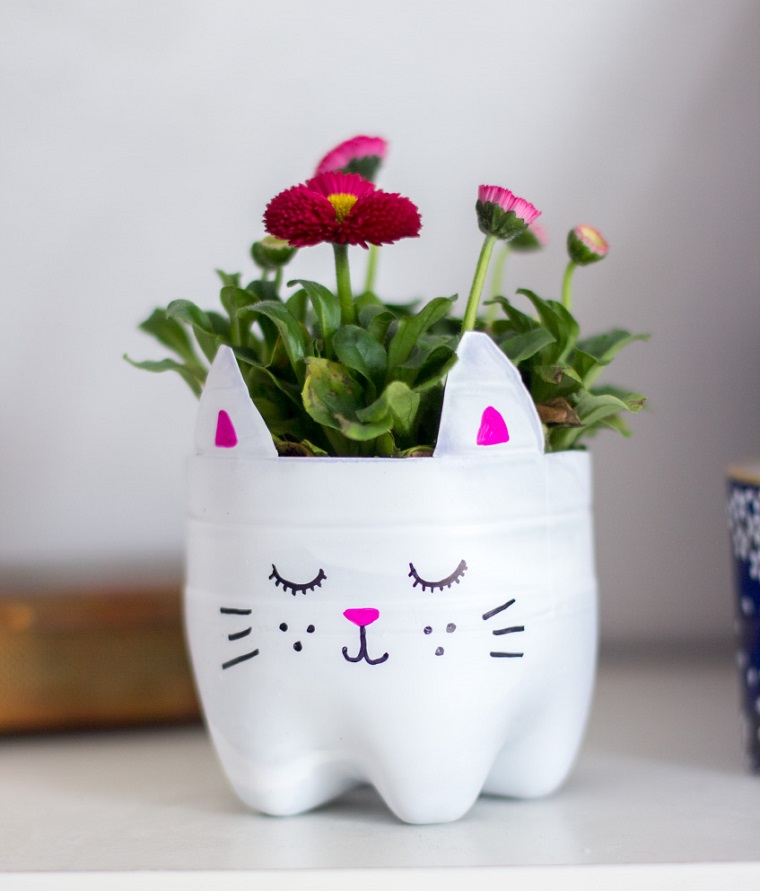 Decorare la casa con un vaso realizzato da una bottiglia di plastica, dipinta di bianco con il viso di un gattino 