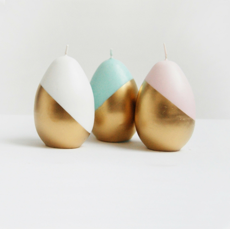 delle candele realizzate con delle uova di pasqua da colorare oro, bianco, azzurro e rosa