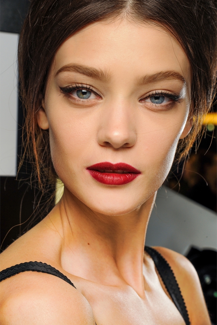 una proposta di makeup rossetto rosso con gli occhi blu truccati con dell'eye liner nero