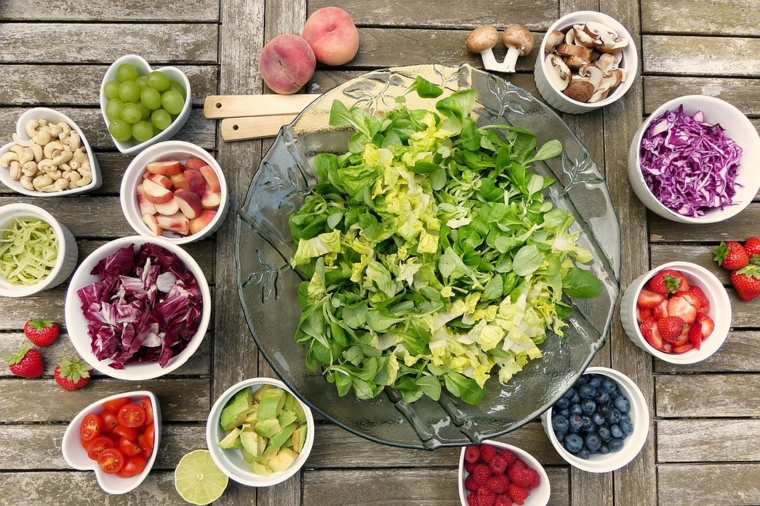 Ingredienti per insalata in ciotole su un tavolo di legno, insalatiera di vetro 